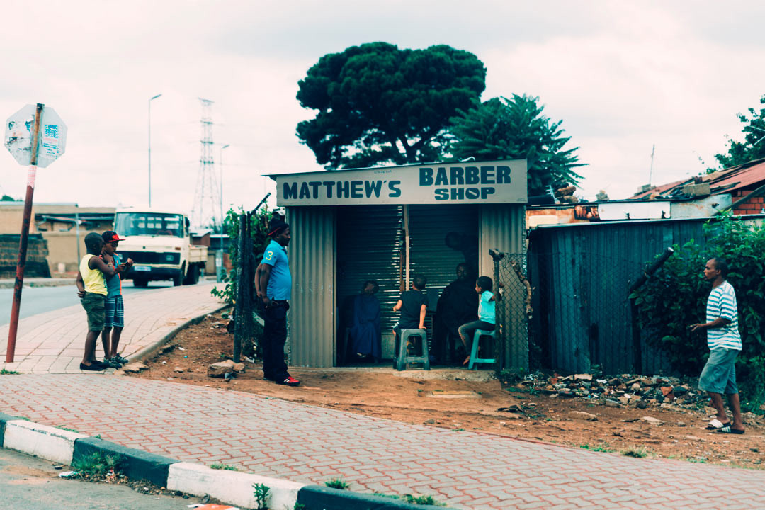 The local barber in Soweto, where an estimated 3-6 million people live, many in simple tin houses.